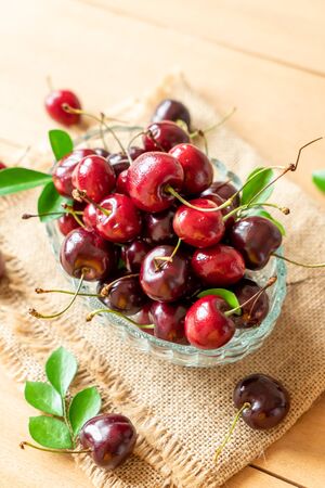 Fresh cherries in bowl  on wood backgroundの写真素材