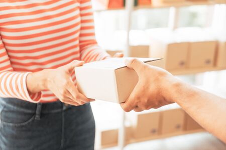Asian woman receiving delivery package - selective focus pointの写真素材