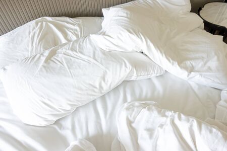 Messy bed, White pillow with blanket on bed unmade