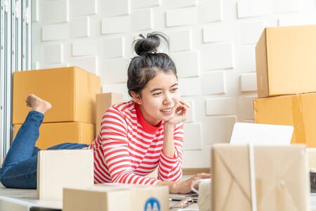 Asian Women business owner working at home with packing box on workplace - online shopping SME...