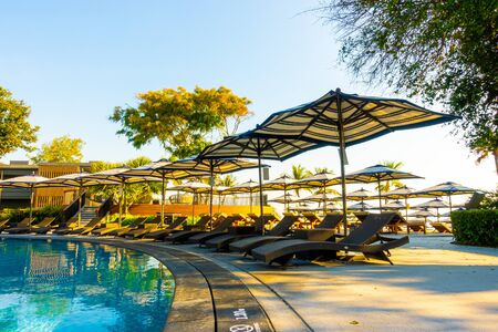 Beautiful tropical beach and sea with umbrella and chair around swimming pool in hotel resort for travel and vacation conceptのeditorial素材