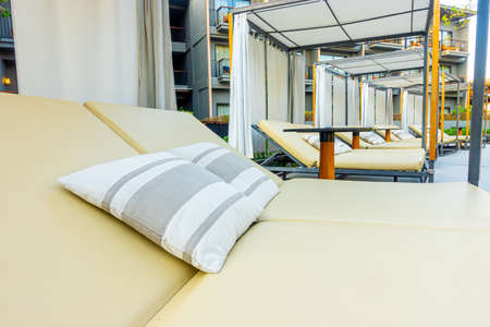 Umbrella and chair sofa around outdoor swimming pool in hotel resort for travel holiday vacation conceptの写真素材