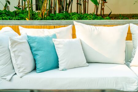 Comfortable pillows on outdoor patio chair and table in garden