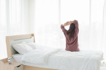 beautiful Asian women on bed and waking up in the morningの写真素材