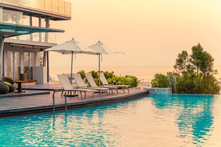 chair pool around swimming pool in hotel resort - holidays and vacations concept