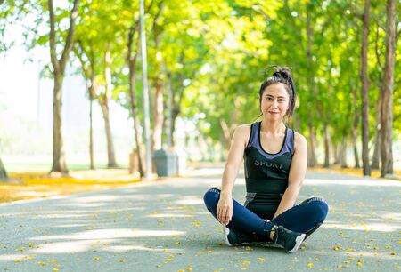 Asian woman sitting and relax after exercise at park