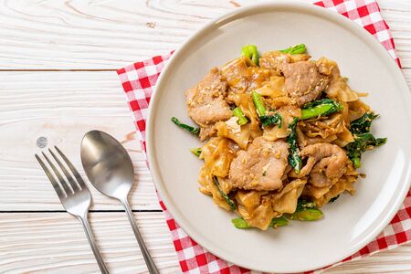 Stir-fried rice noodle with black soy sauce and pork and kale - Asian food styleの写真素材