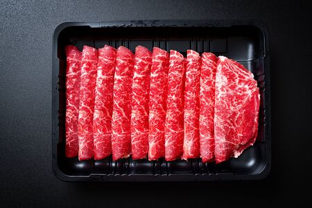 fresh beef raw sliced with marbled texture served for Sukiyaki and Shabu or Yakinikuの写真素材