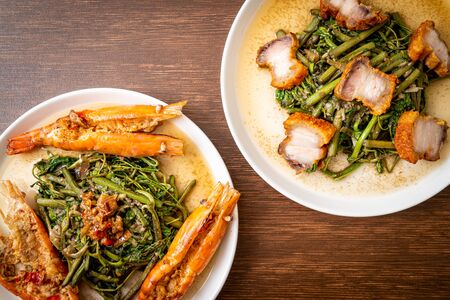 Stir-fried water mimosa with crispy pork belly and river prawns on plateの写真素材