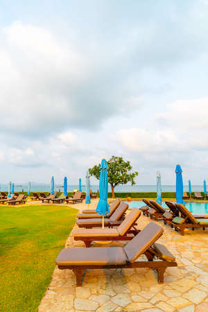 chair pool or bed pool and umbrella around swimming pool with sea beach background at Pattaya in Thailandのeditorial素材