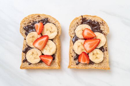 whole wheat bread toasted with fresh banana, strawberry and chocolate for breakfastの写真素材