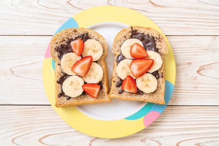 whole wheat bread toasted with fresh banana, strawberry and chocolate for breakfastの写真素材