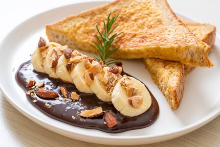 French toast with banana chocolate and almonds for breakfastの写真素材