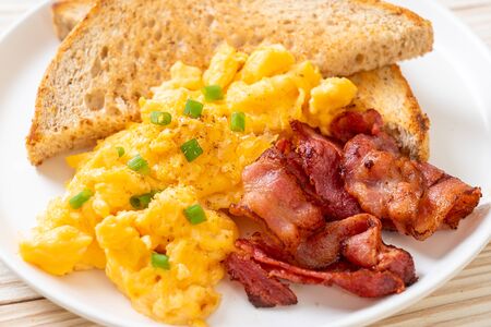 scrambled egg with bread toasted and bacon for breakfastの写真素材