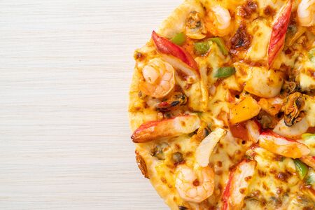 seafood (shrimps, octopus, mussel and crab) pizza on wood trayの写真素材