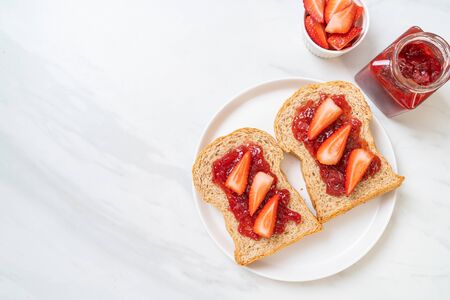 homemade whole wheat bread with strawberry jam and fresh strawberryの写真素材
