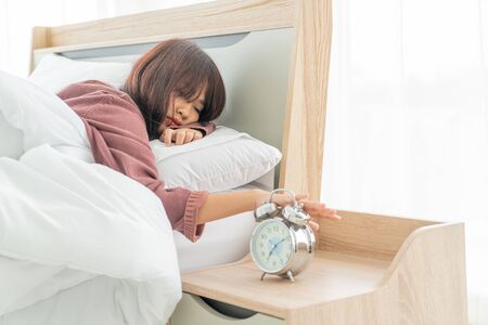 beautiful Asian women on bed and waking up in the morningの写真素材