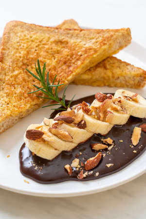 French toast with banana chocolate and almonds for breakfastの写真素材