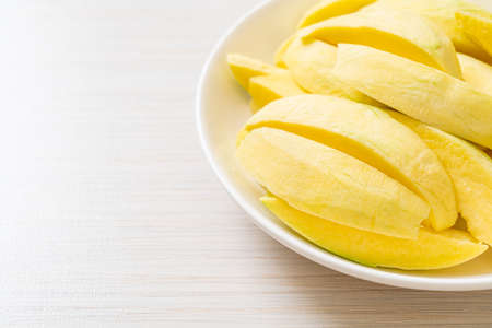fresh green and golden mango sliced on plateの写真素材