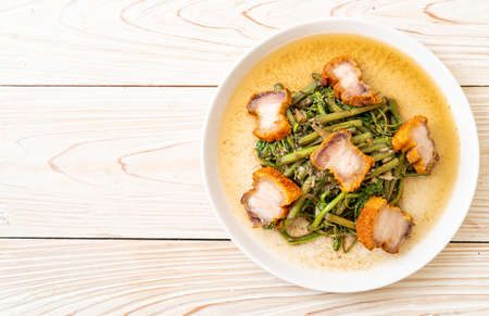 Stir-fried water mimosa with crispy pork belly on plate