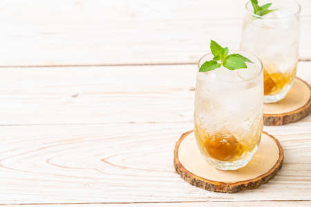 iced plum juice with soda and peppermint on wood table - refreshment drinkの写真素材