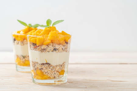 fresh mango yogurt with granola in glass - healthy food styleの写真素材