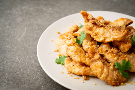 fried fish with garlic on plateの写真素材