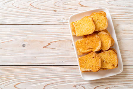 baked crispy bread with butter and sugar on plate