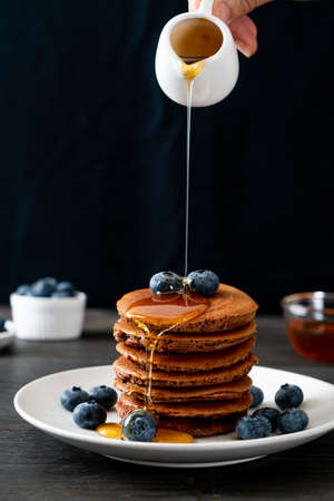 chocolate pancake stack with blueberry and honey on plateの写真素材