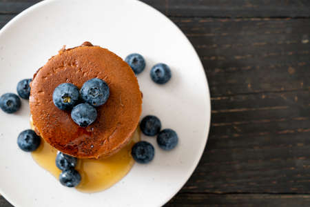 chocolate pancake stack with blueberry and honey on plateの写真素材