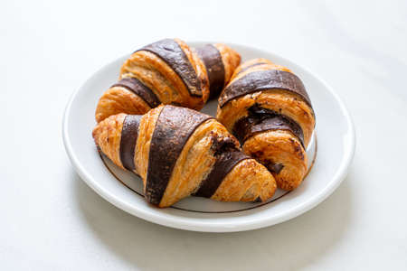 fresh croissant with chocolate on plate