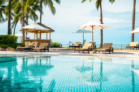 Beautiful tropical beach and sea with umbrella and chair around swimming pool in hotel resort for...
