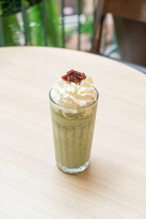 matcha green tea latte blended with whipped cream and red bean in coffee shop cafe and restaurantの写真素材