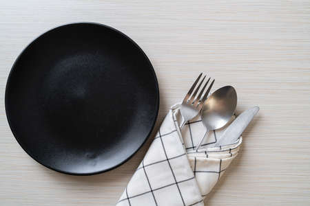 empty plate or dish with knife, fork and spoon on wood tile backgroundの写真素材