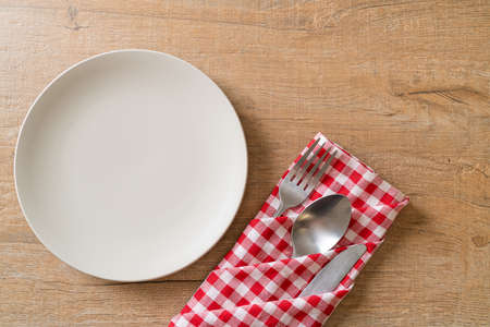 empty plate or dish with knife, fork and spoon on wood tile backgroundの写真素材
