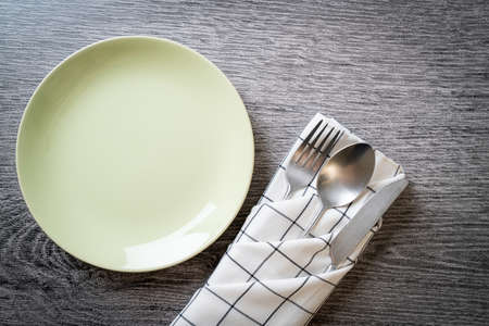 empty plate or dish with knife, fork and spoon on wood tile backgroundの写真素材