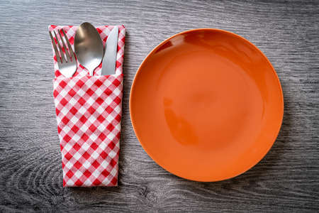 empty plate or dish with knife, fork and spoon on wood tile backgroundの写真素材