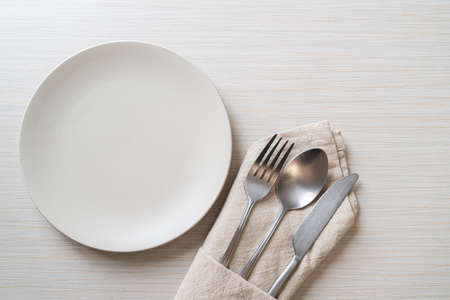 empty plate or dish with knife, fork and spoon on wood tile backgroundの写真素材