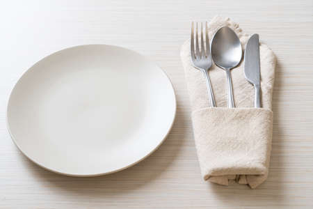 empty plate or dish with knife, fork and spoon on wood tile backgroundの写真素材