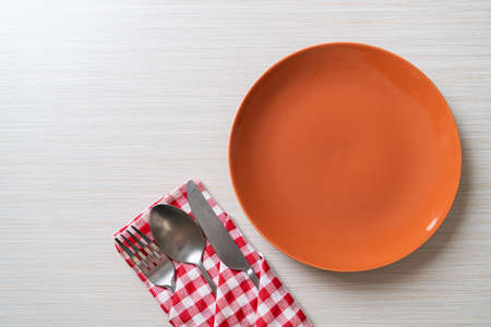 empty plate or dish with knife, fork and spoon on wood tile backgroundの写真素材