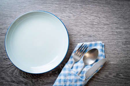 empty plate or dish with knife, fork and spoon on wood tile backgroundの写真素材