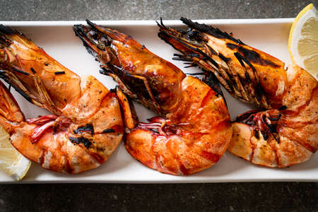grilled tiger prawns or shrimps with lemon on plate