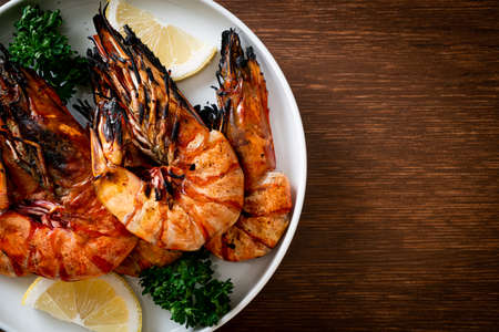 grilled tiger prawns or shrimps with lemon on plateの写真素材