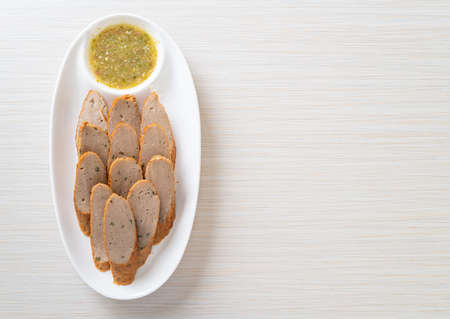 fried Chinese fish cake or fish ball line sliced with spicy seafood dipping sauce