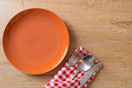 empty plate or dish with knife, fork and spoon on wood tile backgroundの写真素材