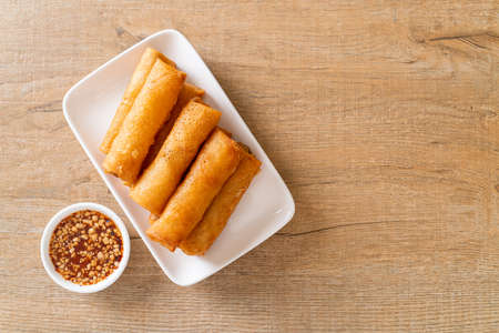 deep fried spring roll with sauce on white plate