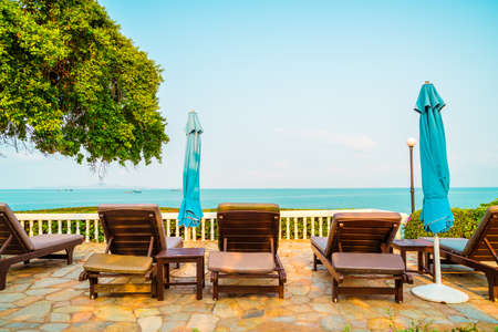 chair pool and umbrella around swimming pool with coconut palm tree - Holidays and vacation concept