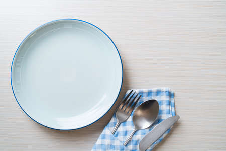 empty plate or dish with knife, fork and spoon on wood tile backgroundの写真素材