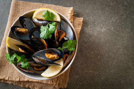 fresh mussels with herbs in a bowl with lemon