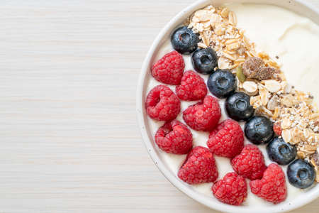homemade yogurt bowl with raspberry, blueberry and granola  - healthy food styleの写真素材